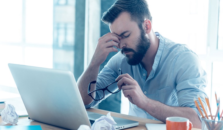 Persona trabajando en computadora con buena postura y luz natural